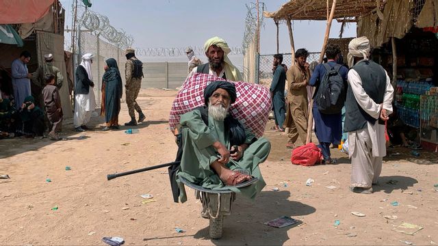 En äldre afghansk man transporteras på en skottkärra vid gränsövergången i Chaman i Pakistan den 20 augusti. Foto: AP/TT.