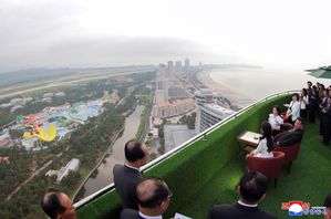 Nordkoreas ledare Kim Jong-Un sitter ned till höger i bild tillsammans med sin fru och dotter. De blickar ut över Nordkoreas nya semesterort, Wonsan-Kalma. Bilden distribueras av diktaturens nyhetsbyrå KCNA. Foto: KCNA via AP/TT