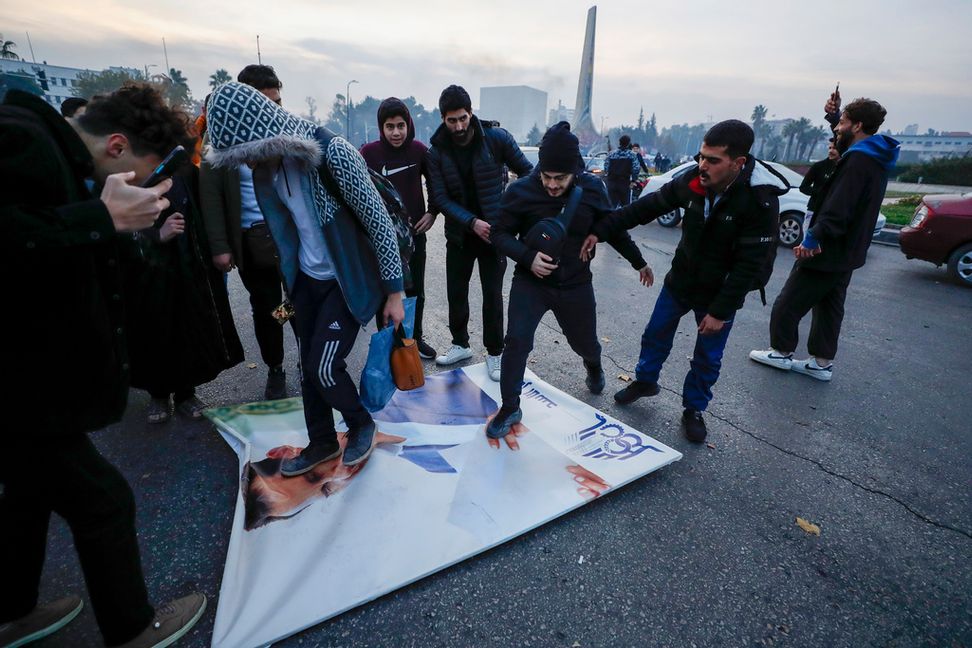 Invånare i Damaskus firar al-Assad-regimens fall och trampar på en bild av den störtade presidenten. Foto: Omar Sanadiki/AP/TT