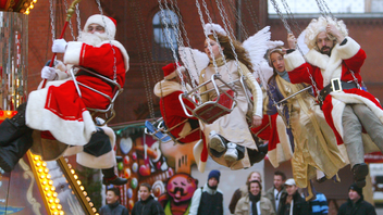 Tomtar i slänggunga vid julmarknaden i Berlin. Foto: Markus Schreiber/AP/TT