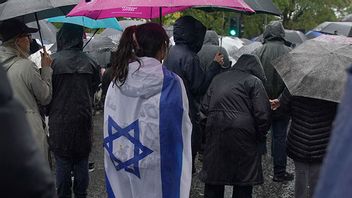 Kvinna iförd den israeliska flaggan under en högtidsstund för offren för en terrorattack mot en synagoga i Manchester i oktober. Bild: AP Photo/Ian Hodgson