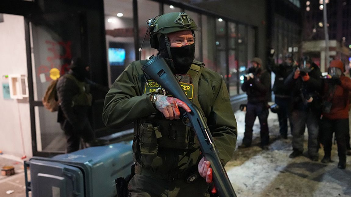 En federal agent står vakt utanför hotellet där oroligheterna skedde. Foto: Adam Gray /AP/TT