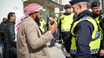 Man i Rinkeby i samtal med polisen i samband med en koranbränning i Rinkeby Foto: Henrik Montgomery/TT