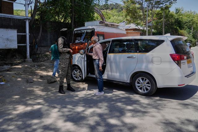En indisk soldat talar med en turist utanför en trädgård i Srinagar efter att myndigheterna stängt den. Foto: Mukhtar Khan/AP/TT