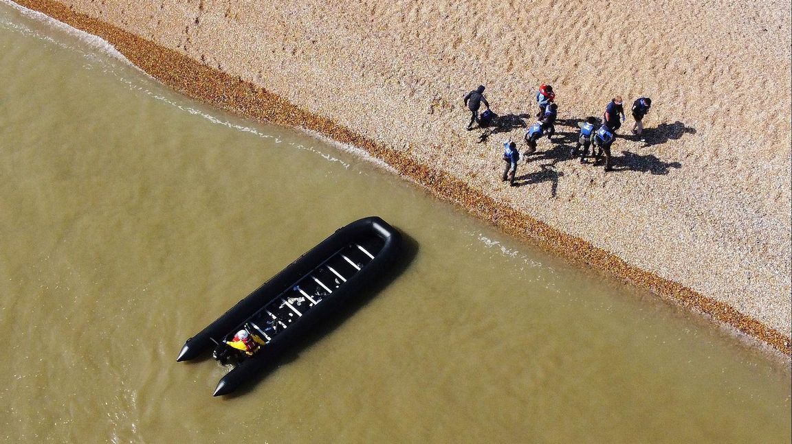 En grupp människor som tros vara migranter går i land i byn Kingsdown i Kent i södra England i tisdags. Foto: Gareth Fuller/AP/TT.